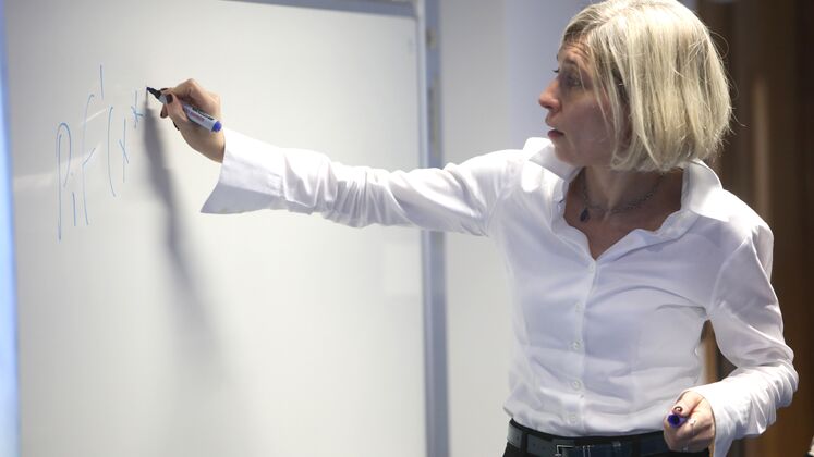 Photo of woman writing on a whiteboard