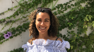 LSE student Andrea Solis-Olivares standing in front of an ivy-covered wall