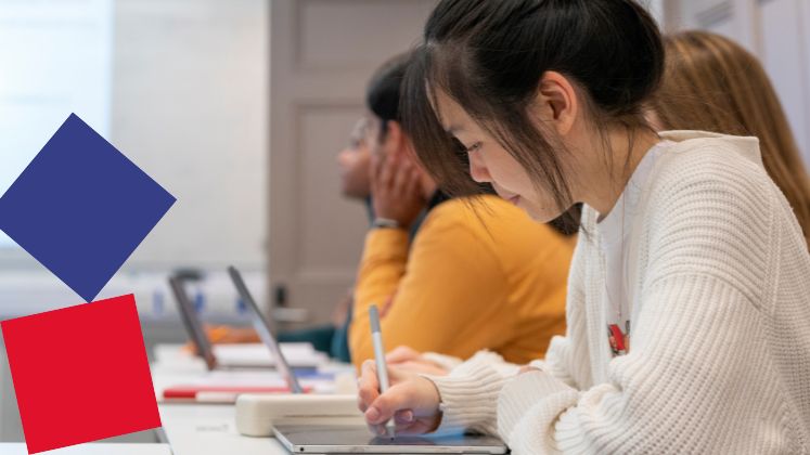 A student writes on an iPad in class.
