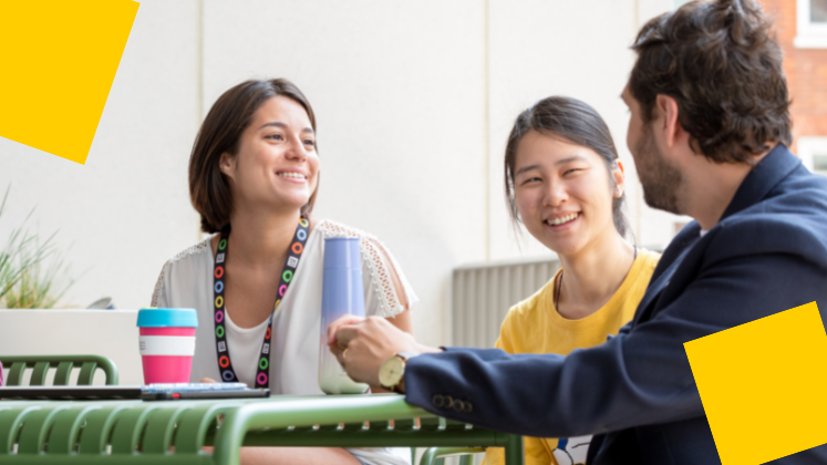 Three students smiling and talking