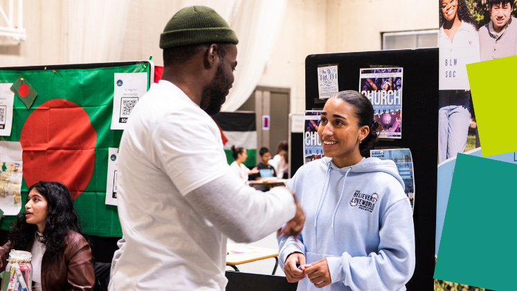 Two students talking at the Welcome Fair in Marshall Building