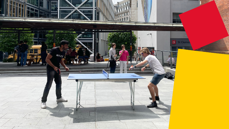 Two men playing table tennis on the Library Plaza