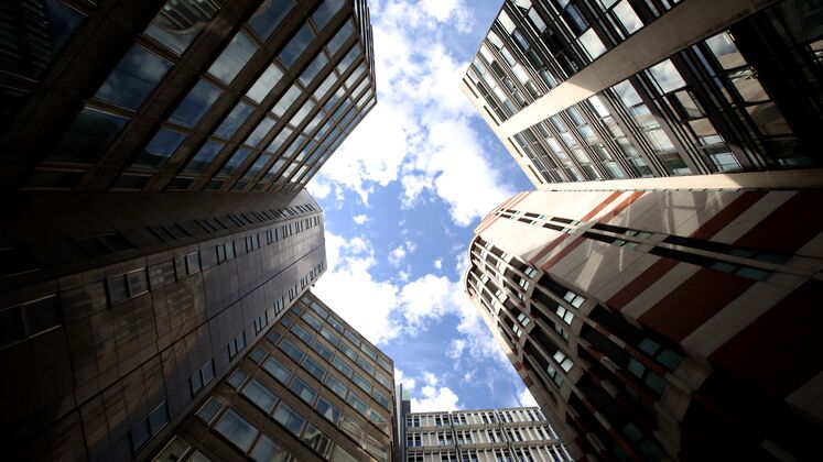 Looking up at the sky between tall buildings