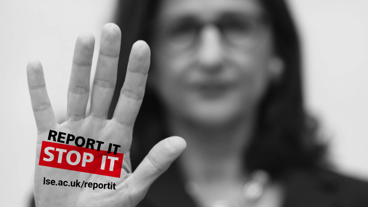 A woman holds her hand up to the camera with the words 'report it, stop it,' across her palm.