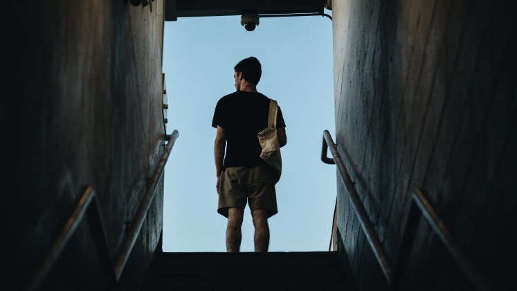 A man faces away at the top of some stairs