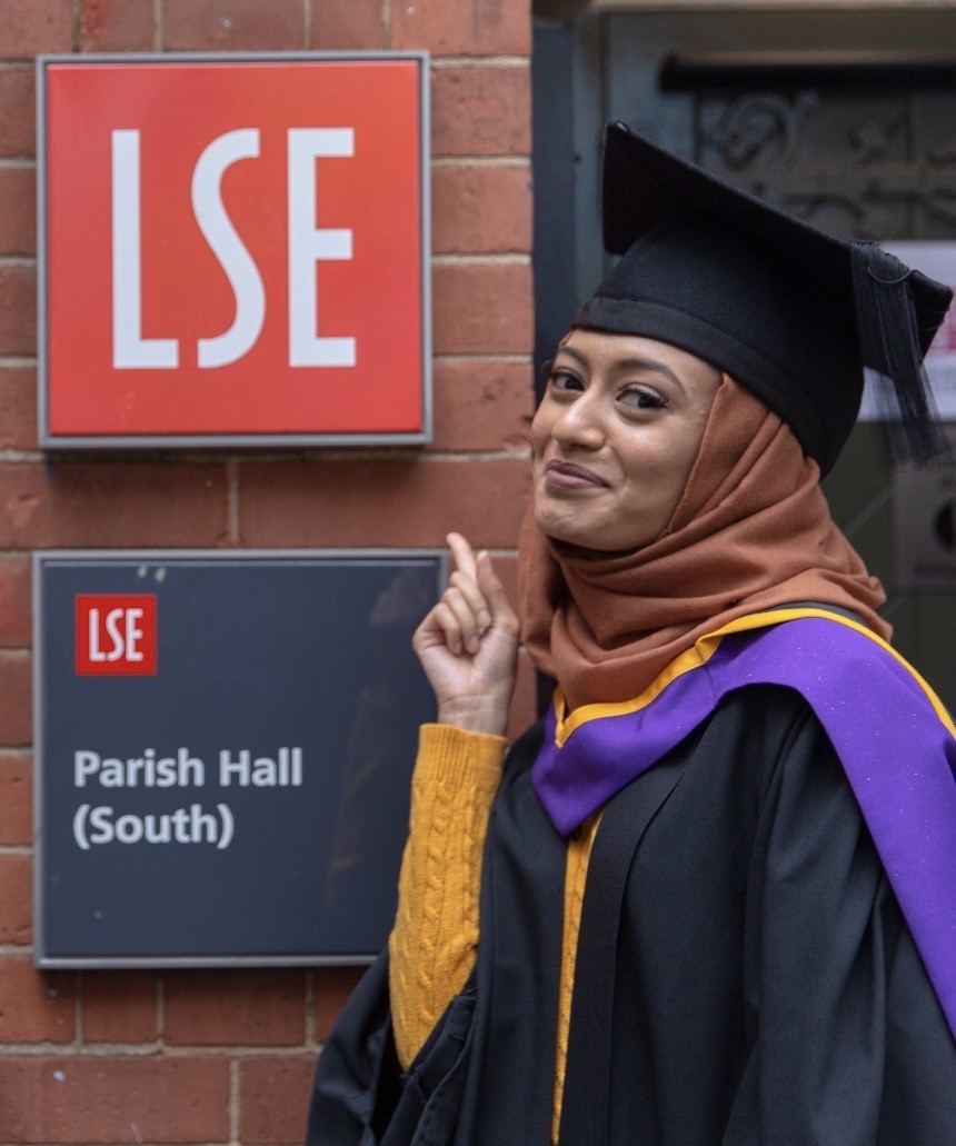 Fatema Begum graduating picture beside LSE logo
