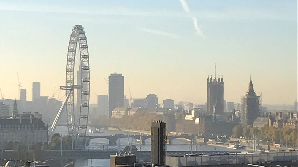 An early morning landscape photo of the London Eye, Big Ben, the Thames and surrounding buildings