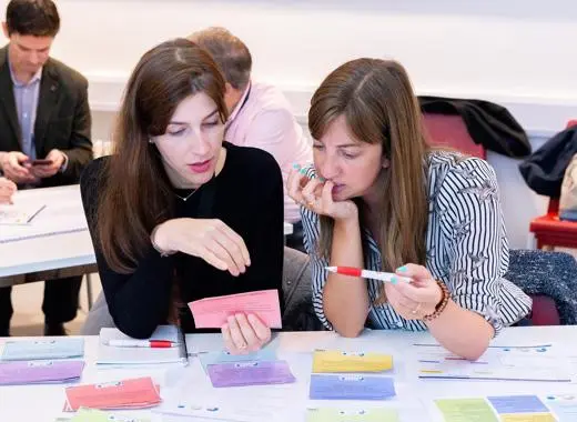 two colleagues discussing ideas at a table covering in post-it notes