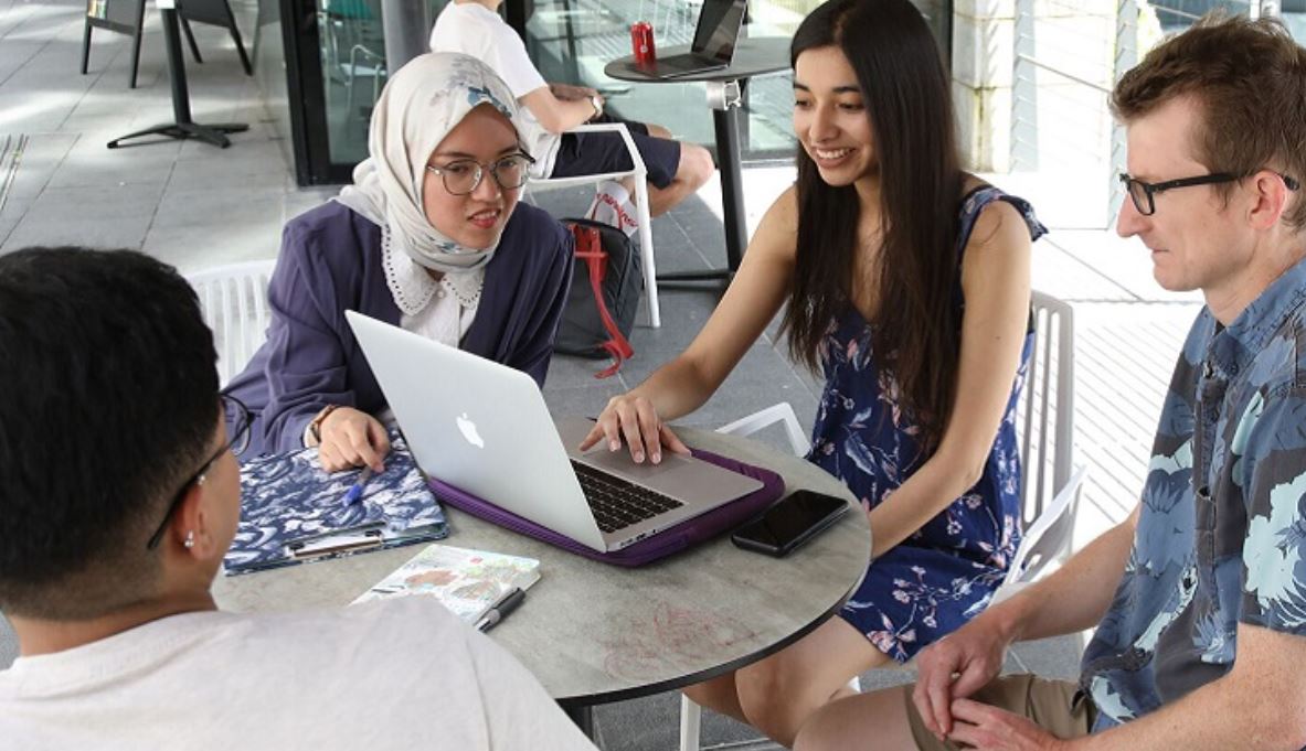 students at a table discussing a presentation