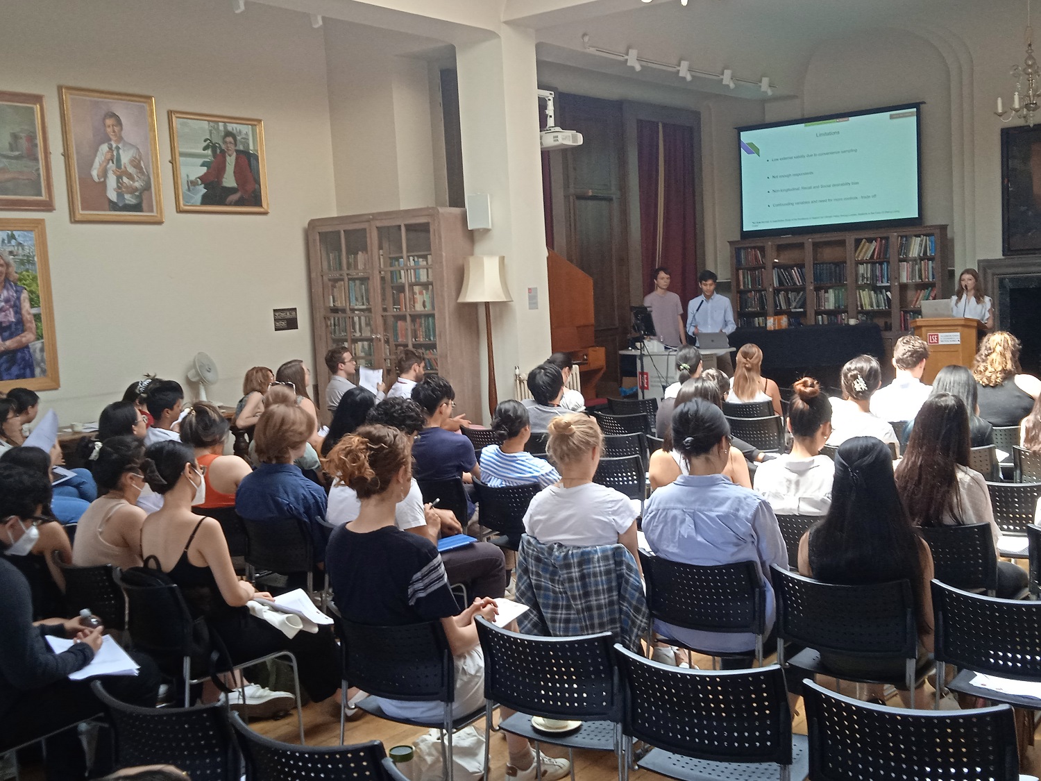 students sitting in a packed hall watching a presentation