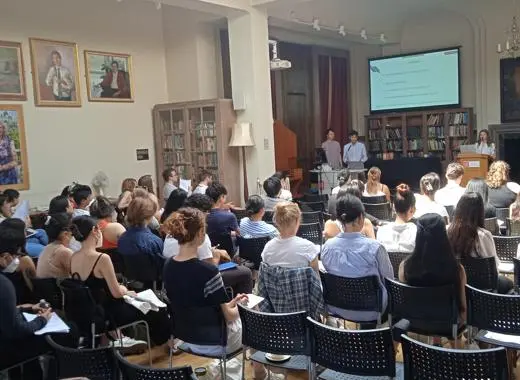 students sitting in a packed hall watching a presentation