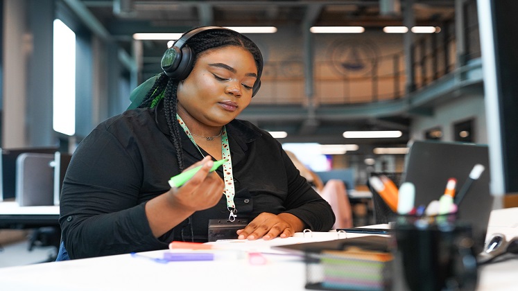 Individual with noise cancelling headphones and sunflower lanyard