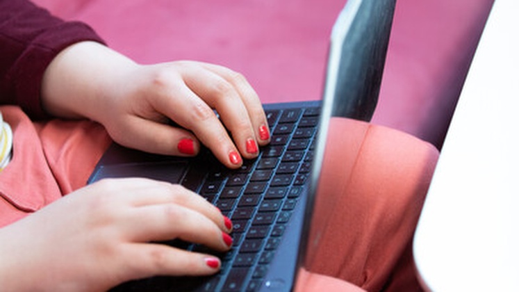 Close-up of someone typing on a laptop