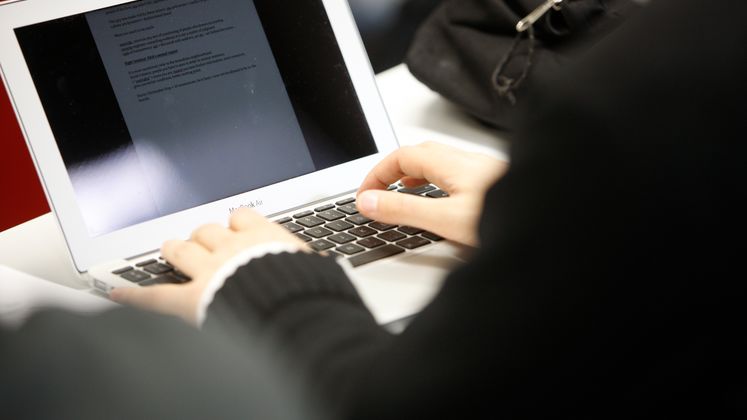 Photo of person typing on a laptop