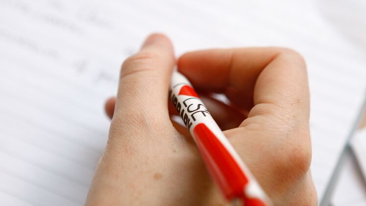 Photo of a hand holding a pen and writing