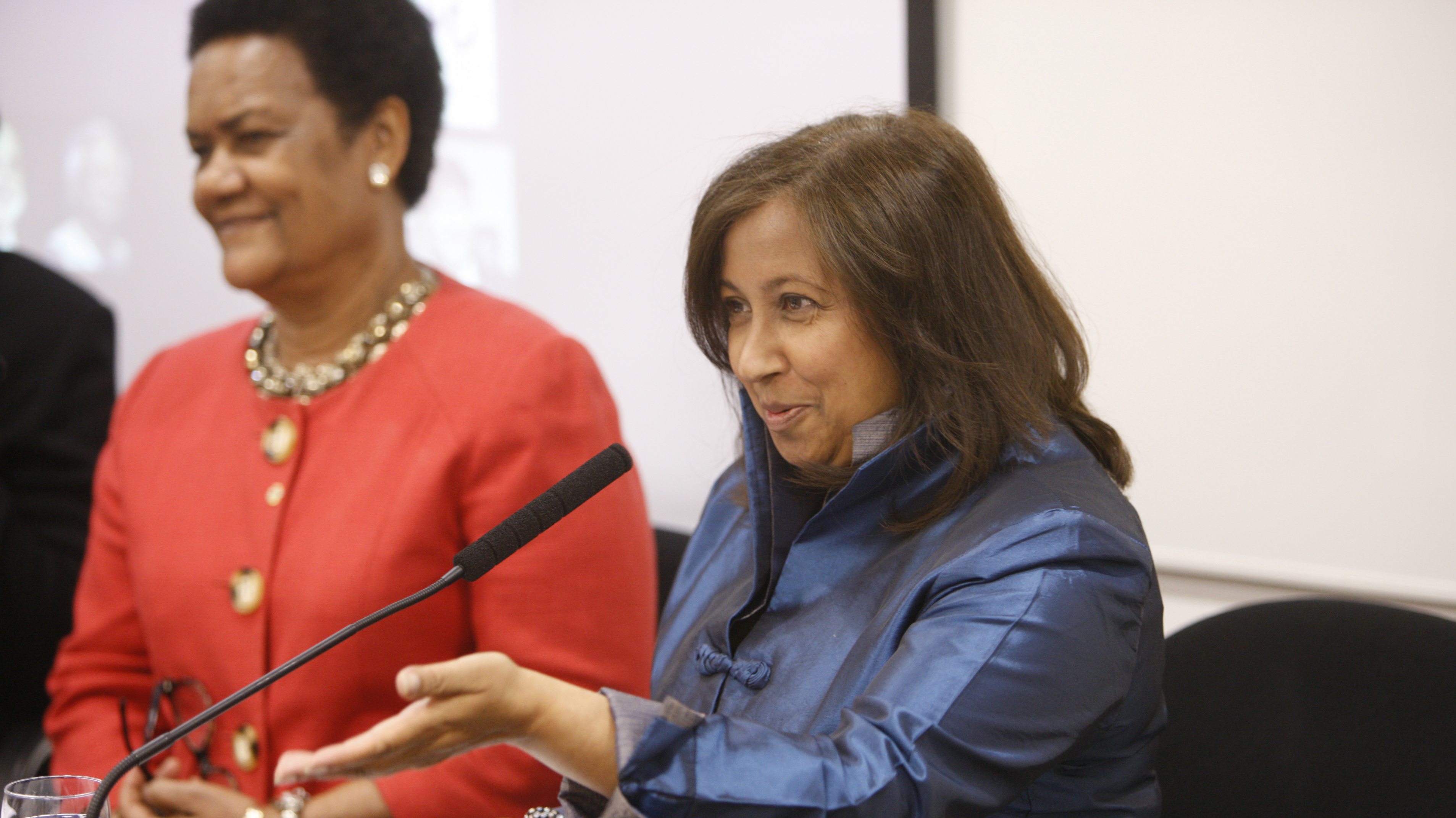 Two women are sat while contributing to a panel discussion