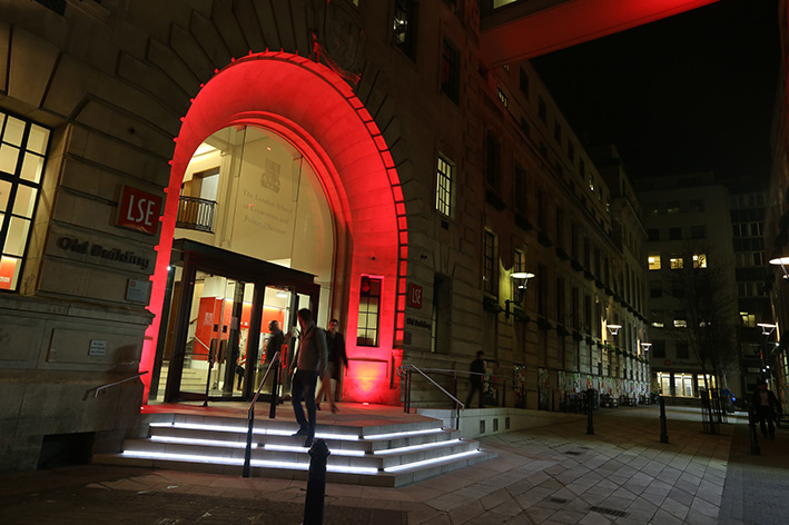 The Old Building at night, with the entrance illuminated in red