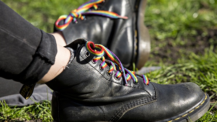 A pair of black boots with rainbow laces
